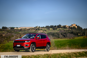 Jeep Compass – front three-quarter, red on a country road