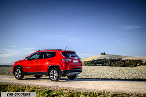 Jeep Compass – rear three-quarter, red on a dirt road