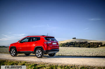 Jeep Compass – rear three-quarter, red on a dirt road