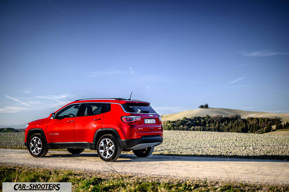 Jeep Compass – rear three-quarter, red on a dirt road