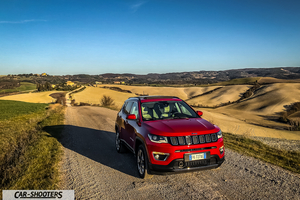 Jeep Compass – front three-quarter, red on a country road