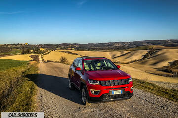 Jeep Compass – front three-quarter, red on a country road