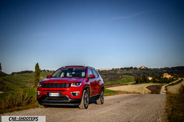 Jeep Compass – front three-quarter, red on a country road