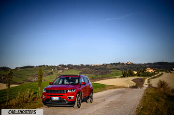 Jeep Compass – front three-quarter, red on a country road