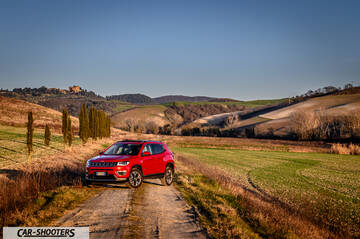 Jeep Compass – front three-quarter, red on a country road