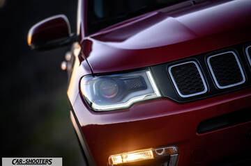 Jeep Compass – front three-quarter, dark red front headlight close-up