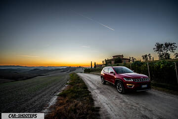 Jeep Compass – front three-quarter, red on a country road