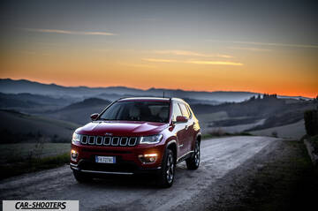 Jeep Compass – front three-quarter, red against a mountain backdrop