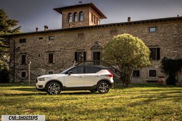 Volvo XC 40 – side profile, white on a lawn in front of an old stone building
