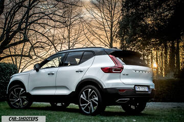 Volvo XC 40 – rear three-quarter, white against a sunset and trees
