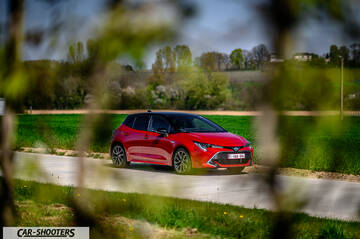 Toyota Corolla Hybrid – front three-quarter, red on a country road
