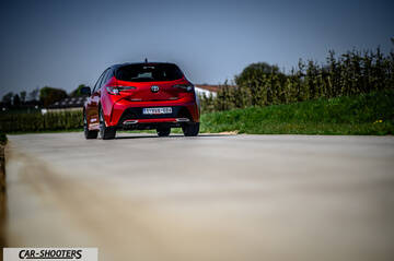 Toyota Corolla Hybrid – rear view, red on a concrete road