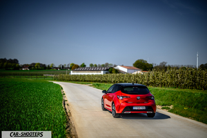 Toyota Corolla Hybrid – rear three-quarter, red on a country road