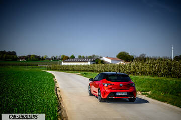 Toyota Corolla Hybrid – rear three-quarter, red on a country road