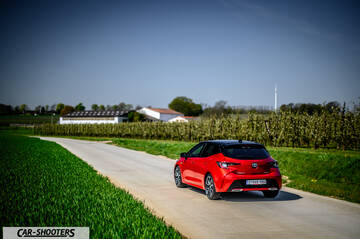 Toyota Corolla Hybrid – rear three-quarter, red on a country road