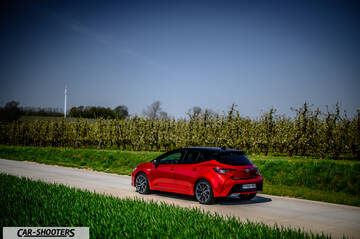 Toyota Corolla Hybrid – rear three-quarter, red on a country road