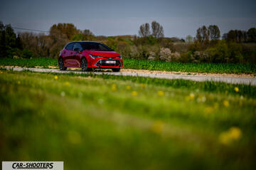 Toyota Corolla Hybrid – front three-quarter, red on a country road