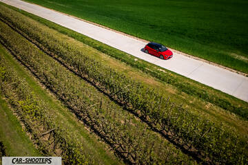 Toyota Corolla Hybrid – front three-quarter, red on a rural road