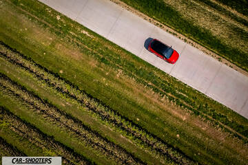 Toyota Corolla Hybrid – side profile, red on a country road