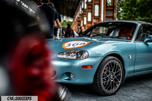 front three-quarter, light blue metallic at a car event