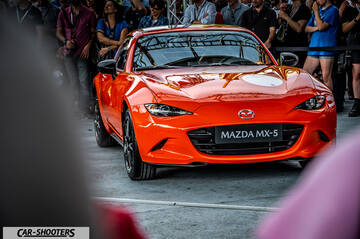 front three-quarter, bright orange surrounded by a crowd