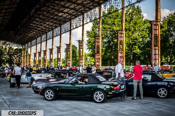 rear three-quarter, dark green in an industrial car meet