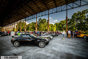 side profile, black under a large industrial pavilion