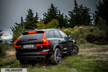 Volvo XC60 Polestar – rear three-quarter, black on a grassy hill