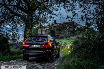 Volvo XC60 Polestar – rear three-quarter, dark red on a rural stone path