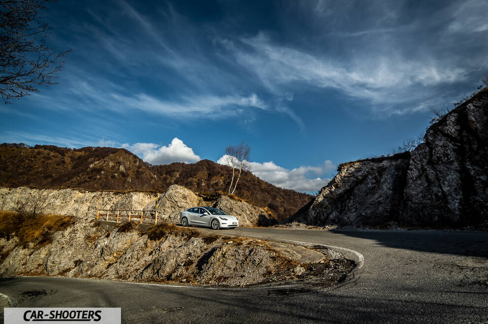 Tesla Model 3 – front three-quarter, white against a mountain backdrop