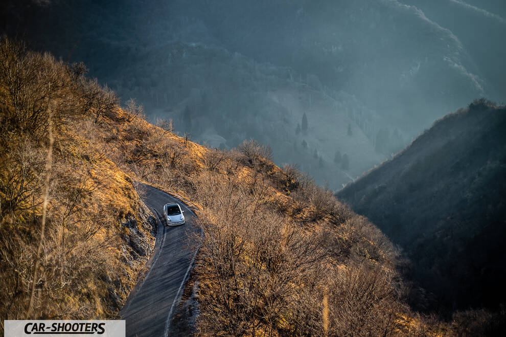 Tesla Model 3 – front three-quarter, white on a winding mountain road