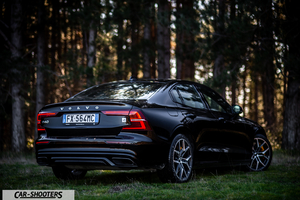 Volvo s60 polestar – rear three-quarter, black against a forest backdrop