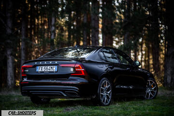 Volvo s60 polestar – rear three-quarter, black against a forest backdrop