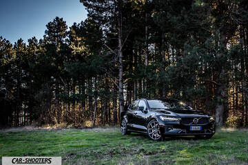 Volvo s60 polestar – front three-quarter, black on a grassy clearing in a forest