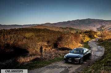 Volvo s60 polestar – front three-quarter, black on a country road against a mountain backdrop
