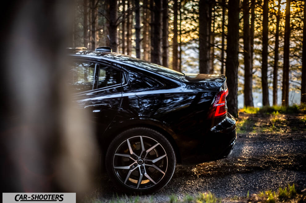 Volvo s60 polestar – rear three-quarter, black against a backdrop of pine trees