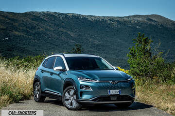 Hyundai Kona electric – front three-quarter, teal against a mountain backdrop