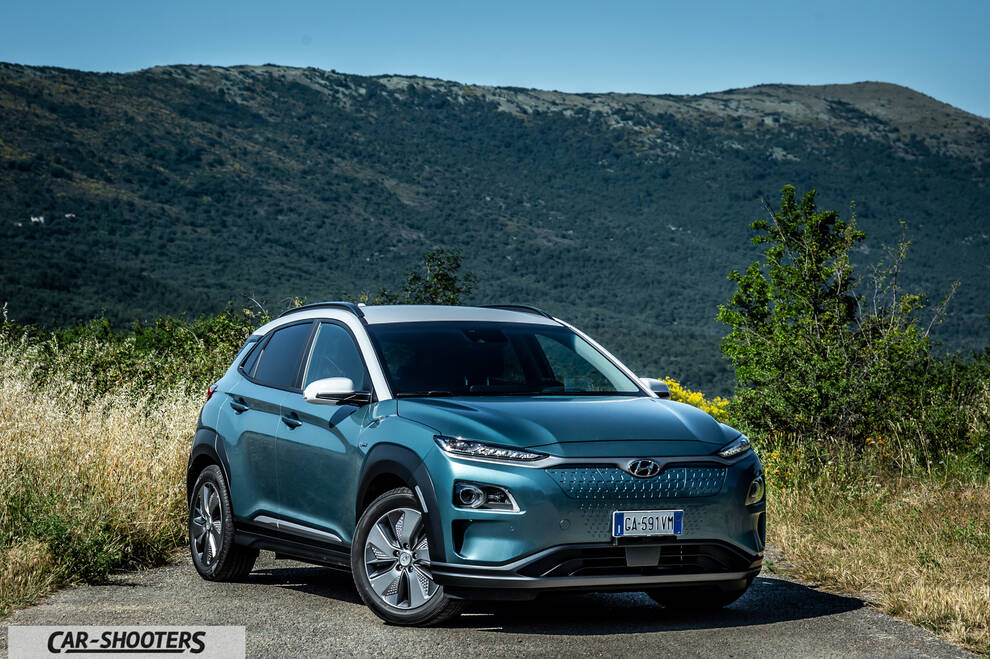 Hyundai Kona electric – front three-quarter, teal against a mountain backdrop