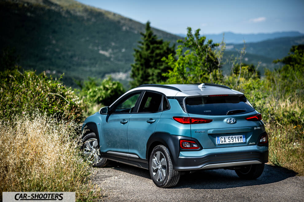 Hyundai Kona electric – rear three-quarter, blue against a mountain backdrop