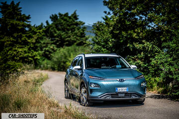 Hyundai Kona electric – front three-quarter, blue on a country road