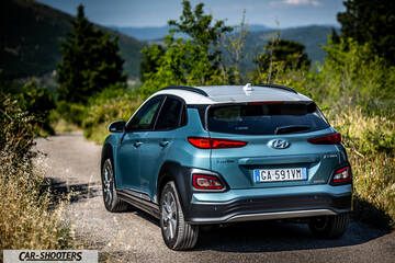 Hyundai Kona electric – rear three-quarter, blue on a country road