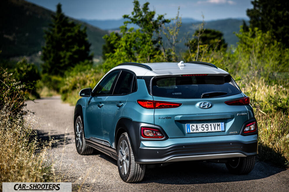 Hyundai Kona electric – rear three-quarter, blue on a country road