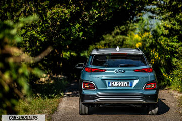 Hyundai Kona electric – rear view, teal on a country road