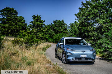 Hyundai Kona electric – front three-quarter, blue on a country road