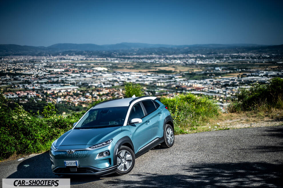 Hyundai Kona electric – front three-quarter, light blue against a city backdrop