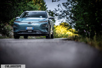 Hyundai Kona electric – front three-quarter, light blue on a country road