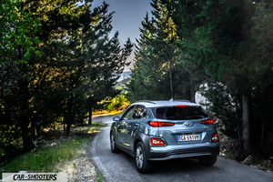 Hyundai Kona electric – rear three-quarter, grey metallic on a country road