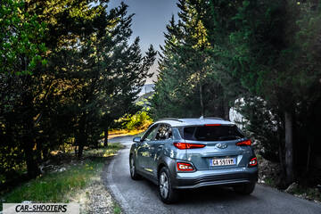 Hyundai Kona electric – rear three-quarter, grey metallic on a country road