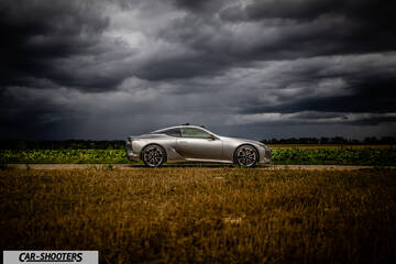Lexus LC500h – side profile, silver metallic on a country road under stormy skies