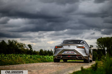 Lexus LC500h – rear view, silver metallic on a country road under a stormy sky